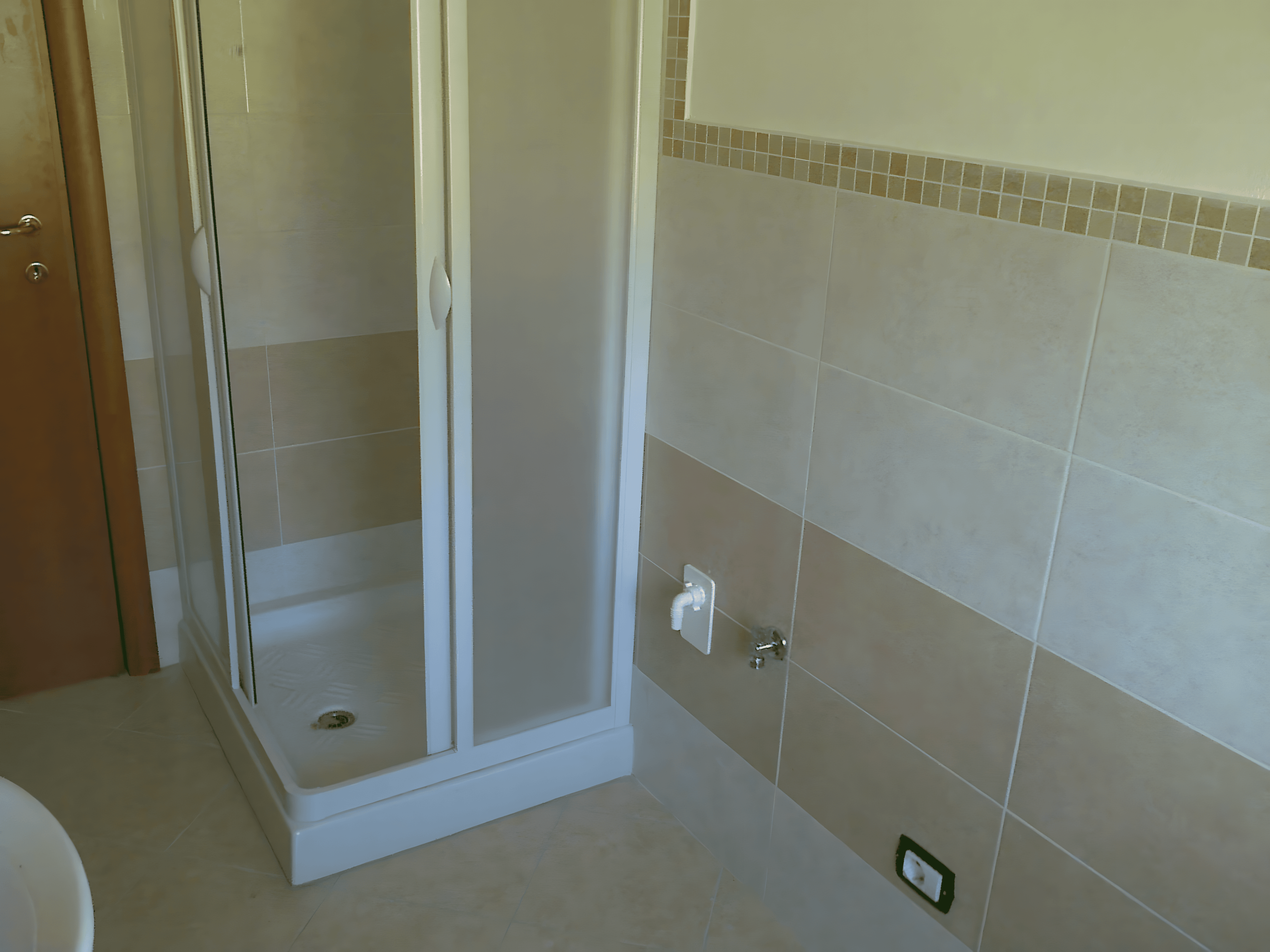 Bagno a piastrelle beige e bianche, con motivetto a cubetti. Realizzato da Edilvos.